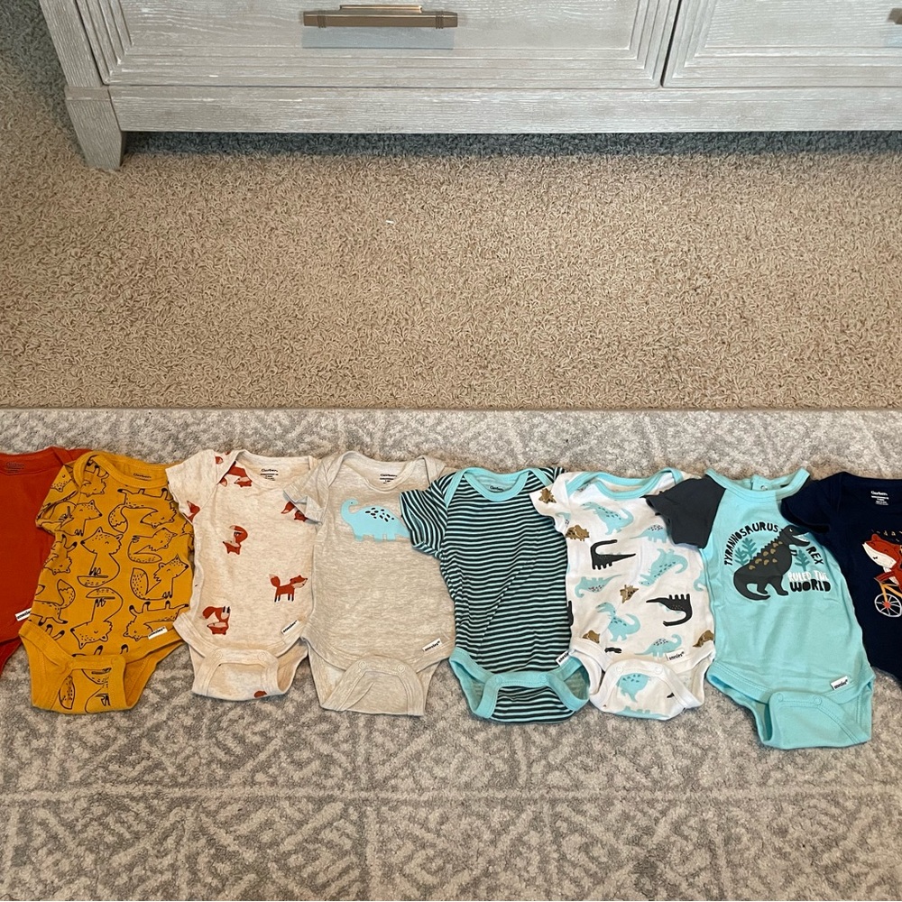 Eight short sleeve onesies by Gerber in a size newborn.